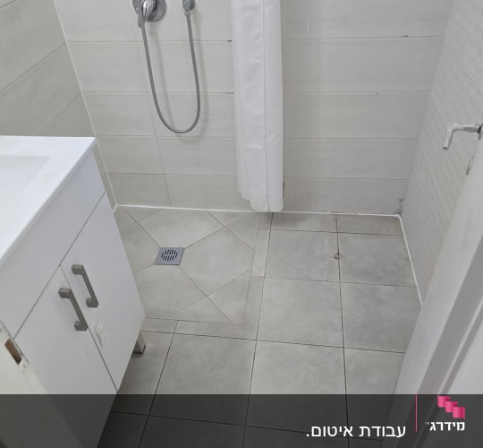 מקלחת עם אריחים ואביזרי מים